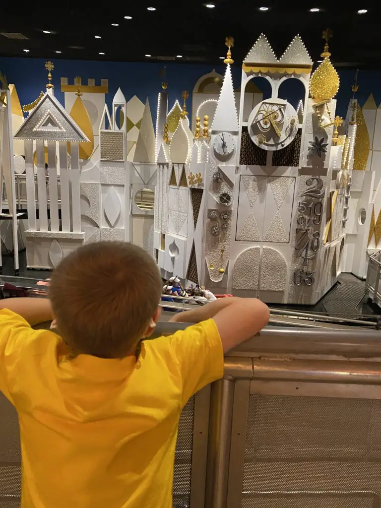 little boy in front of it's a small world at Disney World